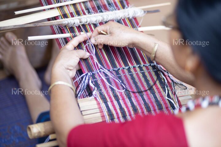 Beautiful design crafting on a colorful traditional Karbi dress in a traditional Karbi handloom by a woman - WM